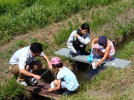 研究所近くの小川で水くみしている写真