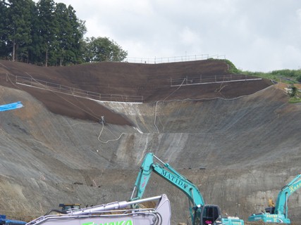 黒い部分が、緑化のための植生基材吹付が完了したところです。の画像