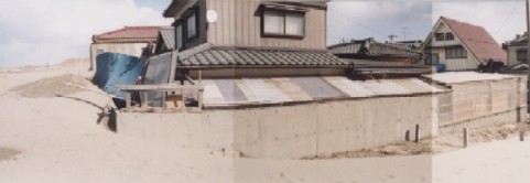 海岸からの飛砂で埋まる住宅