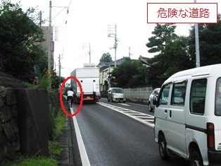 大型車両の脇を自転車が走行している危険な状況の写真です