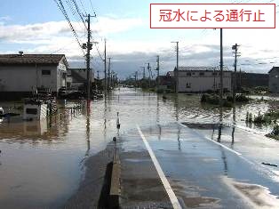豪雨後に道路が冠水し、車両が通行できない状況の写真です
